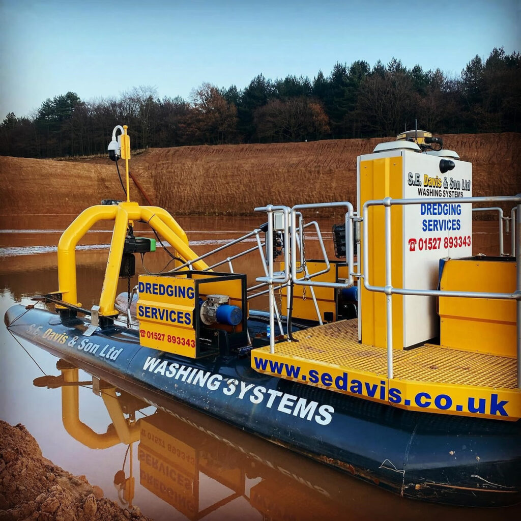 Long-reach excavator dredging silt from a reservoir for S.E. Davis & Son